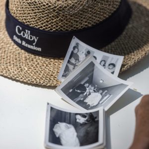 50th Reunion straw hat sits on a table with 3 square black and white photos nearby.