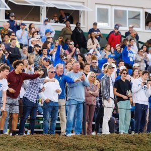 Fans cheer excitedly at a Colby football game during Homecoming