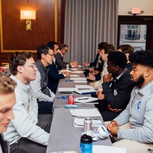 Students talk with alumni and volunteers at Paving the Road in Boston in 2024.
