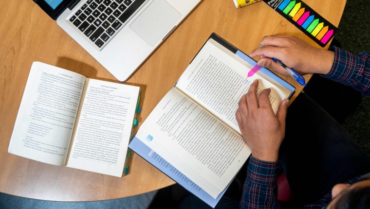 a student reads and annotates a book during a study session