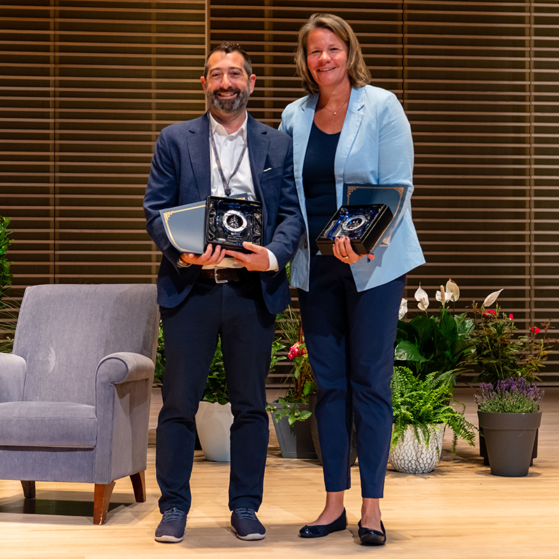 2026 Distinguished Alumna/us Award recipients Reagan Carey ’01 (right) and Zecharia S. Kahn ’01 pose with their awards.